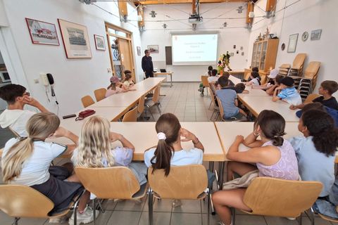 Kinder der Grundschule Stetten verfolgen die Demonstration eines Atemschutzgeräts durch einen Feuerwehrangehörigen.