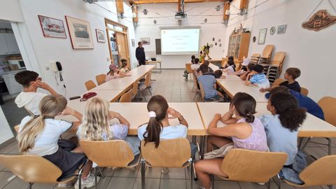 Kinder der Grundschule Stetten verfolgen die Demonstration eines Atemschutzgeräts durch einen Feuerwehrangehörigen.